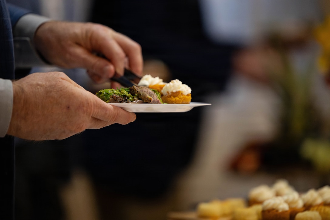 A guest serves himself a plate of food at a social event during the Sergeant Major of the Marine Corps Force Level Summit at Quarters A, New Orleans, March 9, 2026. The summit was held for senior officers and senior enlisted advisors, serving at the Marine Forces level, to discuss important and emerging topics in the Marine Corps. (U.S. Marine Corps photo by Cpl. Van Hoang)