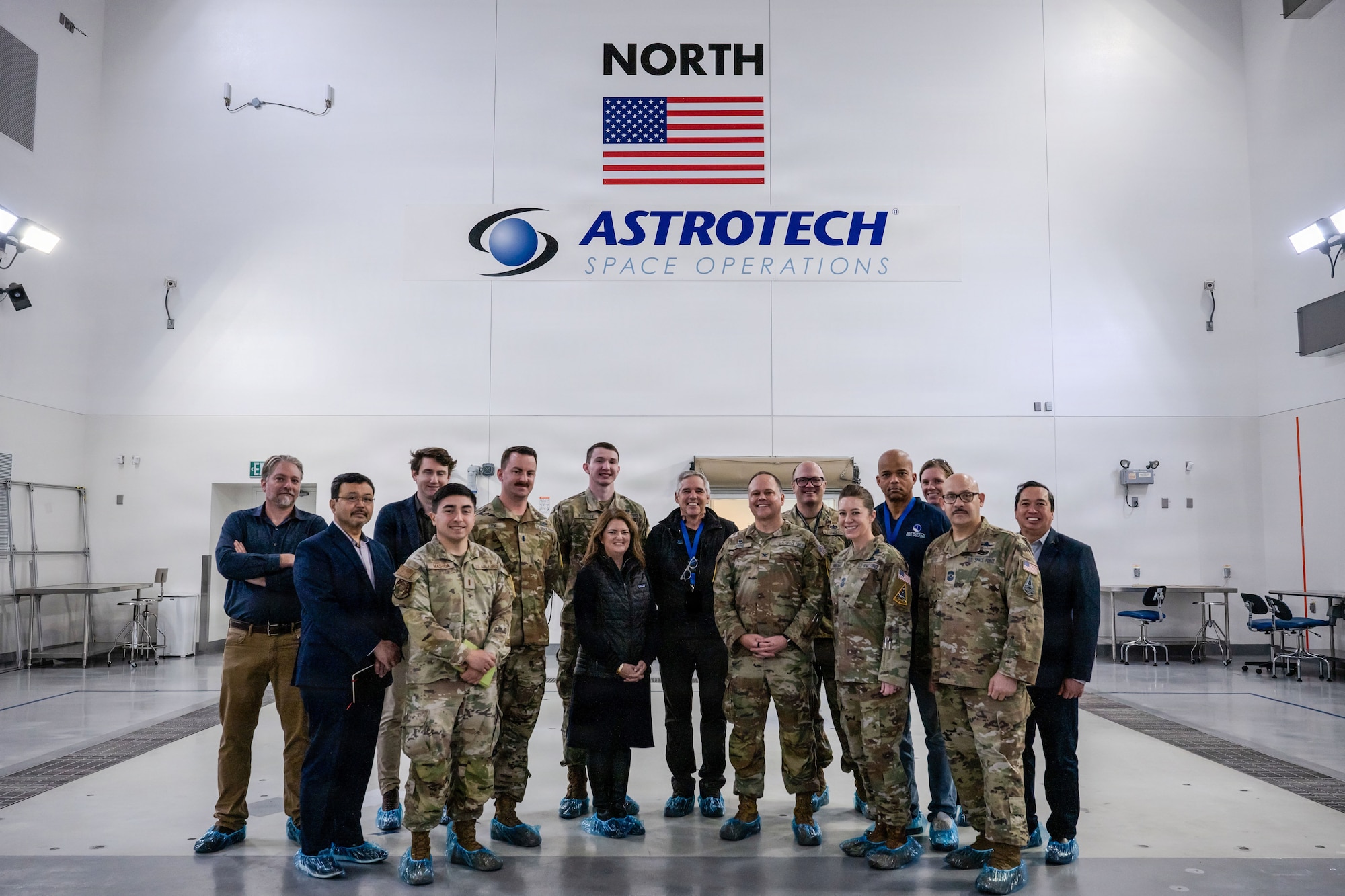 a group of people gather in front of a wall with "Astrotech" painted