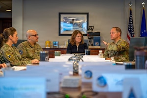 a person sits at a table and briefs 3 other people