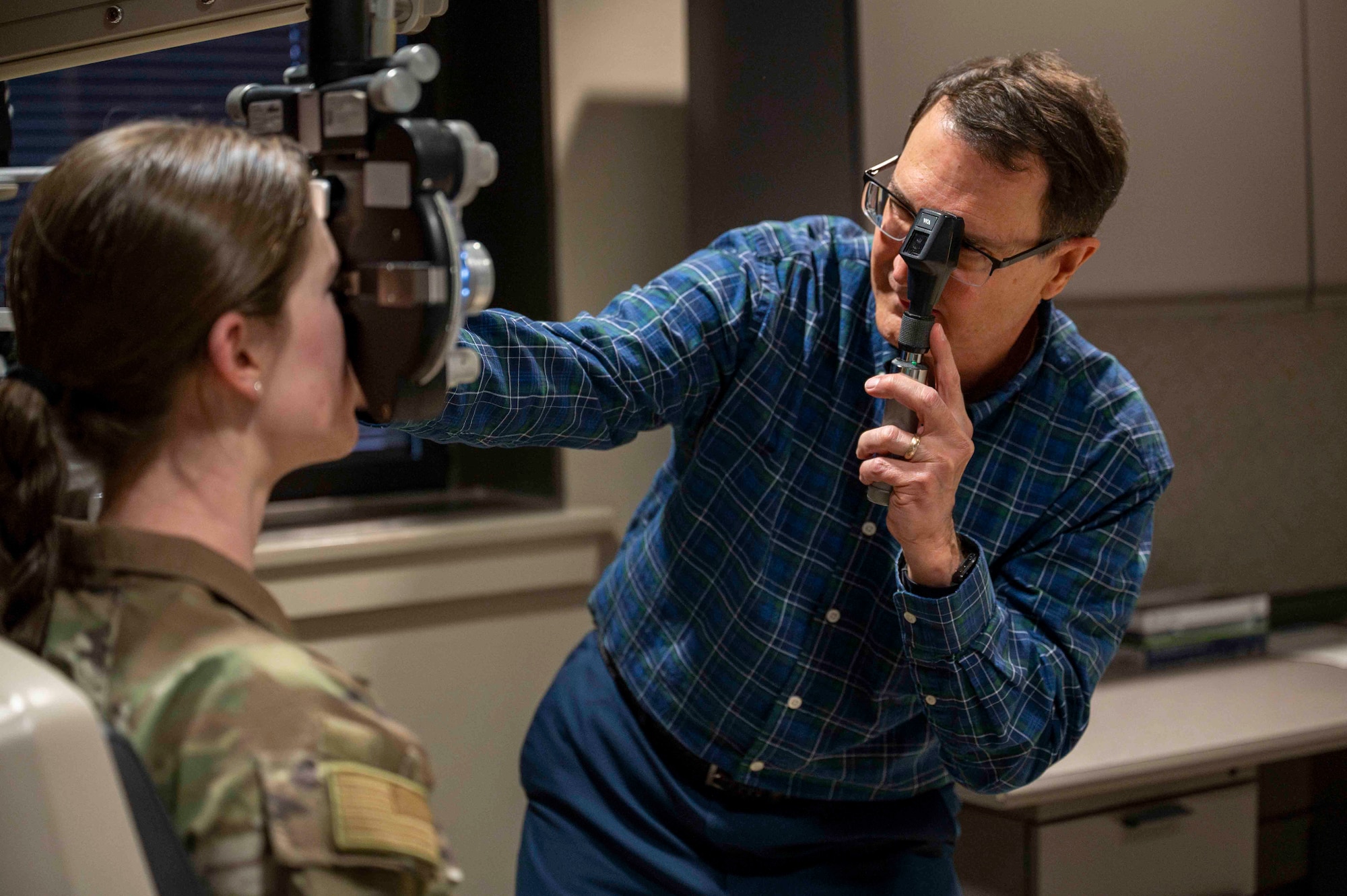 Optometrist performs eye exam on 2nd Lt.