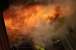 A firefighter with Camp Lejeune Fire and Emergency Services Division oversees firefighters preparing to combat a rollover fire during a live fire training exercise held at the FESD training center on Marine Corps Base (MCB) Camp Lejeune, North Carolina, Sept. 27, 2022. (U.S. Marine Corps photo Sgt. Antonino Mazzamuto)