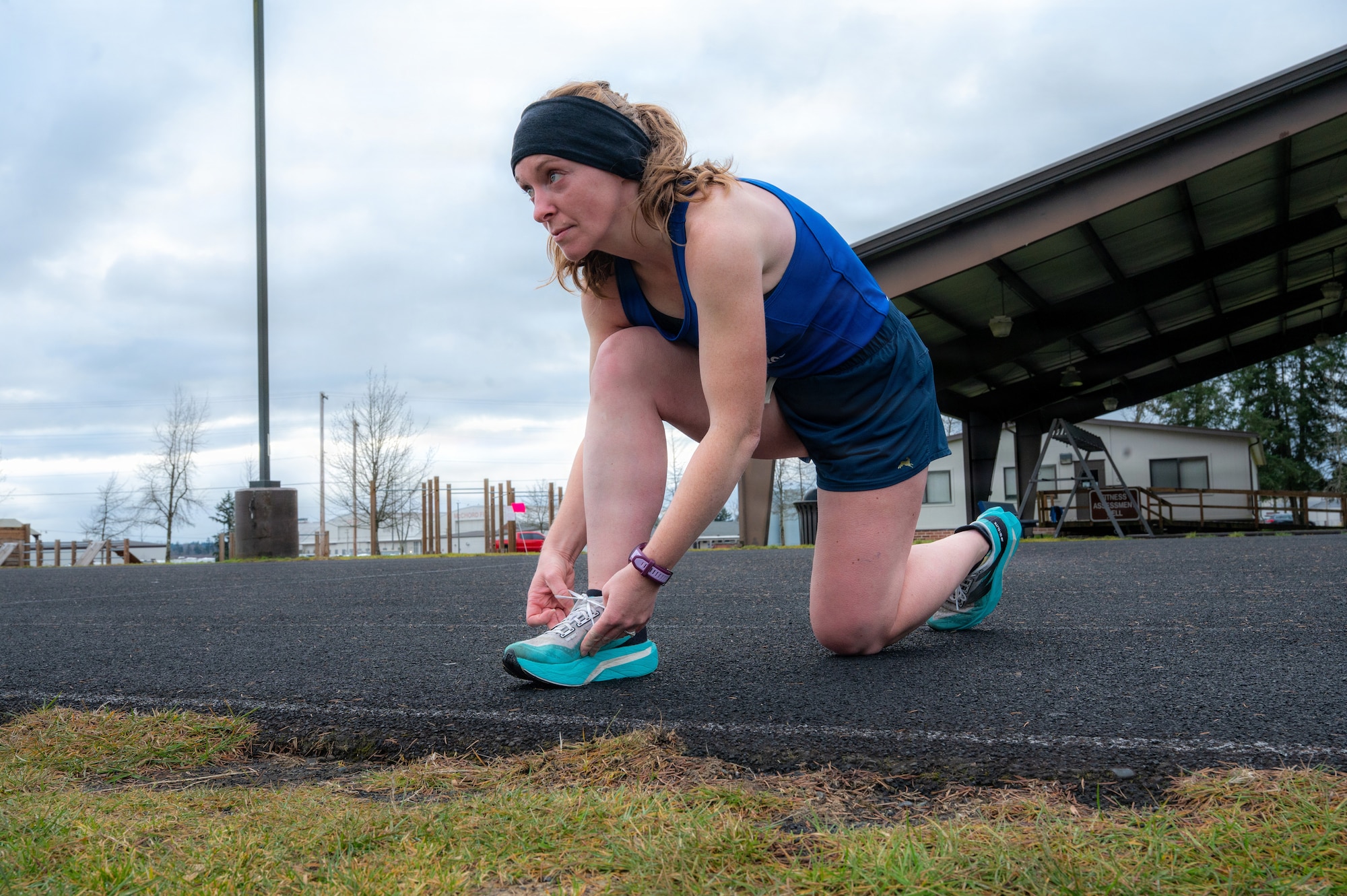 U.S. Air Force Senior Master Sgt. Tiffany Hallmark, 446th Force Support Squadron chief of cyber operations, ties her shoe at Joint Base Lewis-McChord, Wash., on Feb. 27, 2026.