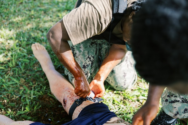 AGANA HEIGHTS (Dec.17, 2025) - A U.S Navy Sailor applies a tourniquet to a simulated casualty, performing hemorrhage control during Tactical Combat Casualty Care (TCCC) training with U.S. Navy Medicine Readiness and Training Command (NMRTC) Guam Sailors held at U.S. Naval Hospital Guam. The Sailor reinforced lifesaving interventions in accordance with the Massive Hemorrhage, Airway, Respiration, Circulation, Hypothermia/Head injury, Pain, Antibiotics, Wounds and Splinting (MARCHPAWS) algorithm, focusing on rapid bleeding control before reassessing and continuing treatment in a safer position. (U.S Navy photo Petty Officer 3rd Class Oluwatomiwo Sogaolu).  Photo name: 251217-N- EM93 -2018