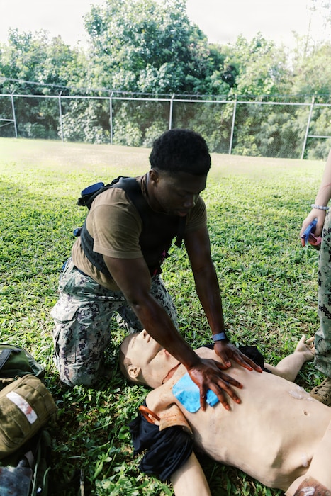 AGANA HEIGHTS (Dec.17, 2025) - Hospitalman Ojurereoluwa Bamgbade, who is assigned to U.S. Navy Medicine Readiness and Training Command (NMRTC) Guam, monitors a simulated casualty’s breathing during Tactical Combat Casualty Care (TCCC) training held at U.S. Naval Hospital Guam. Bamgbade observed the equal rise and fall of the chest to confirm adequate respirations, reinforcing the importance of early airway and breathing assessments before moving on to additional treatment or evacuation. (U.S Navy photo Petty Officer 3rd Class Oluwatomiwo Sogaolu). Photo name: 251217-N- EM93 -2021
