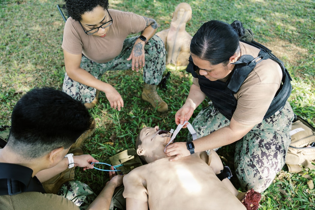 AGANA HEIGHTS (Dec.17, 2025) – Hospital Corpsman 2nd Class Brianna Blackston, a Tactical Combat Casualty Care (TCCC) instructor, evaluates Sailors while they practice doing a cricothyrotomy on a training manikin during a U.S. Navy Medicine Readiness and Training Command TCCC training at U.S. Naval Hospital Guam. The scenario focused on keeping the airway open when other options were no longer possible, helping Sailors learn how to act quickly to keep a casualty breathing in a combat situation. (U.S Navy Photo Petty Officer 3rd Class Oluwatomiwo Sogaolu). Photo name: 251217-N- EM93 -2032