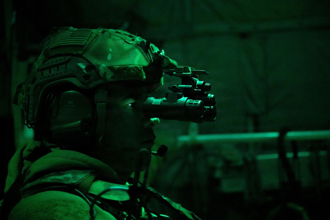 Airmen in combat gear sitting in dark