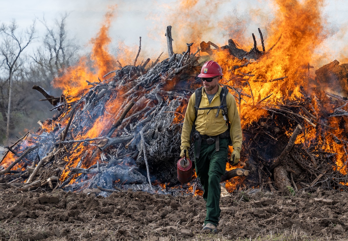 Paul Hensel, Bitter Lake Wildlife Refuge engine captain, performs a controlled burn at McConnell Air Force Base, Kansas, March 18, 2026. Controlled burns are performed to reduce wildfire risk and maintain the base’s ecosystem. (U.S. Air Force photo by Senior Airman Paula Arce)