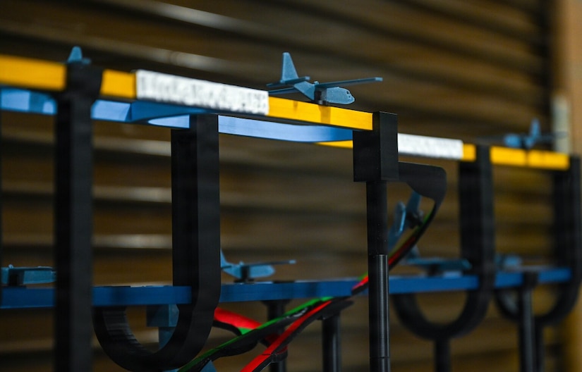 Several small 3D printed model airplanes are displayed in different flight patterns.