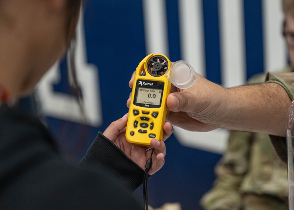 A Kestrel is handed to an Altus High School student during a career fair at Altus High School, Altus, Oklahoma, March 11, 2026. Students learned about how a Kestrel can measure wind speed and temperature pressure. (U.S. Air Force photo by Airman 1st Class Emma Wright)