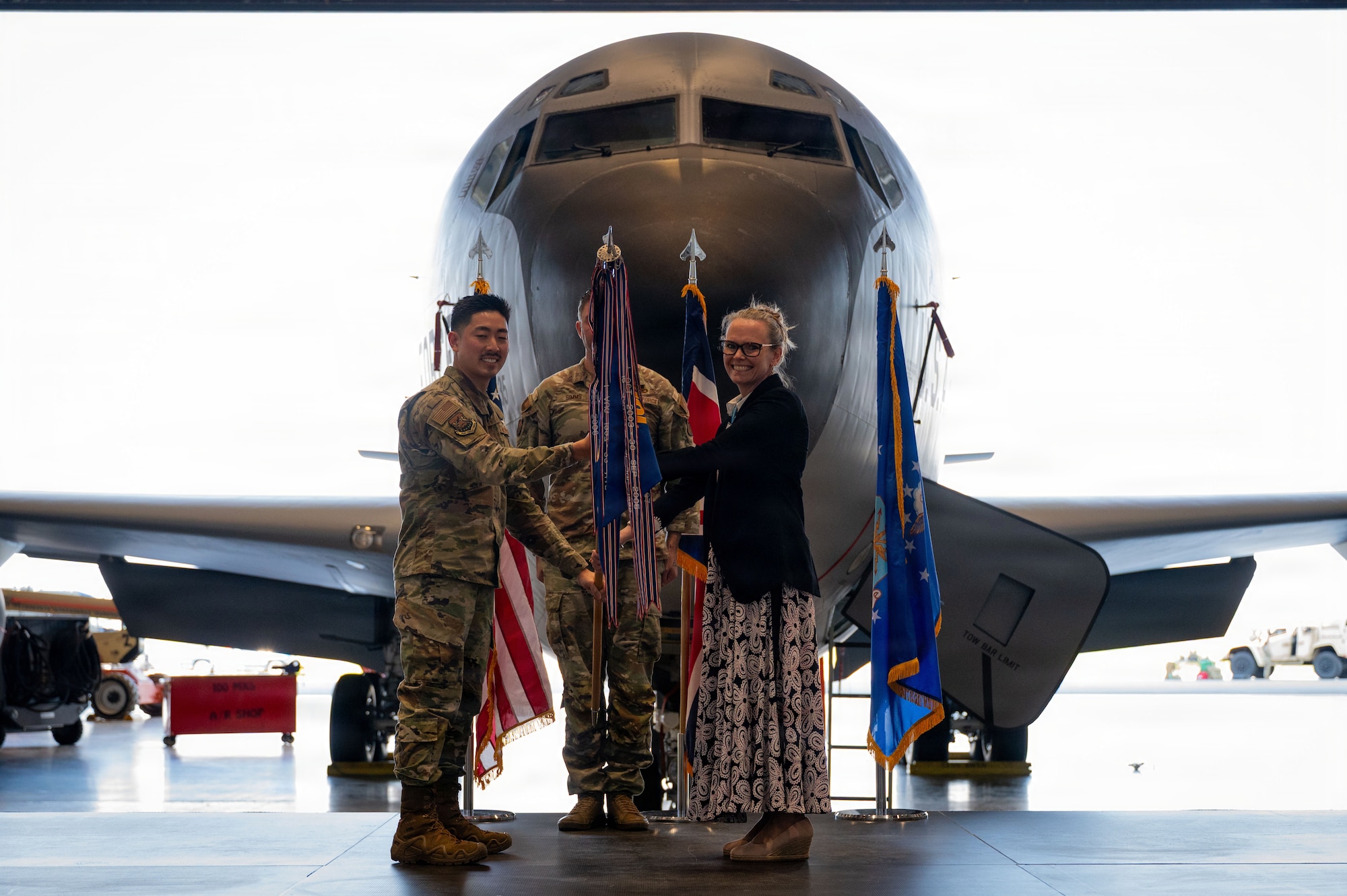 Ms. Emma Arrand receives a guidon from U.S. Air Force Major David Lee, 100th Comptroller Squadron, as she is appointed Honorary Commander of the 100th CS at RAF Mildenhall, England, March 19, 2026.
