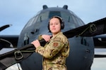Senior Airman Kaylee Hess, an aeromedical evacuation technician with the 187th Aeromedical Evacuation Squadron, 153rd Airlift Wing, Wyoming Air National Guard, stands in front of a C-130 Hercules aircraft assigned to the 153rd Airlift Wing while holding a folded litter in Cheyenne, Wyo., March 5, 2026. Hess was named the 2025 Outstanding Aeromedical Evacuation Crew Member of the Year. Photo by Master Sgt. Jon Alderman.