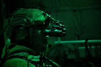 Airmen in combat gear sitting in dark