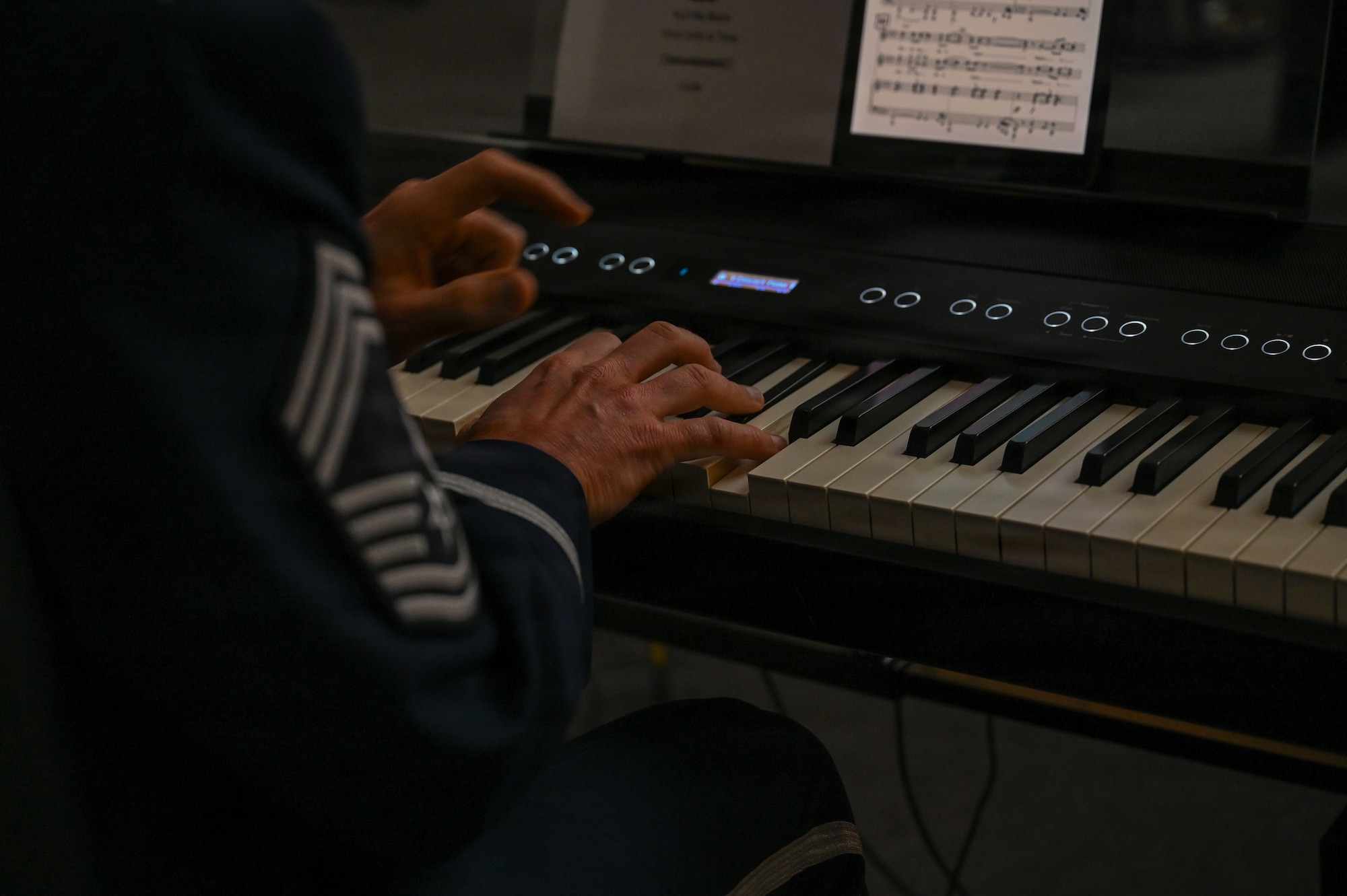 U.S. Air Force Chief Master Sgt. Taylor S. Armstrong, a keyboardist with The U.S. Air Force Band’s Singing Sergeants, plays a selection at the Smithsonian National Museum of American History in Washington, D.C., March 12, 2026. The U.S. Air Force Band vocalists performed while accompanied by a piano, a guitar, and drums. (U.S. Air Force photo by Airman 1st Class Brandon Thomas)