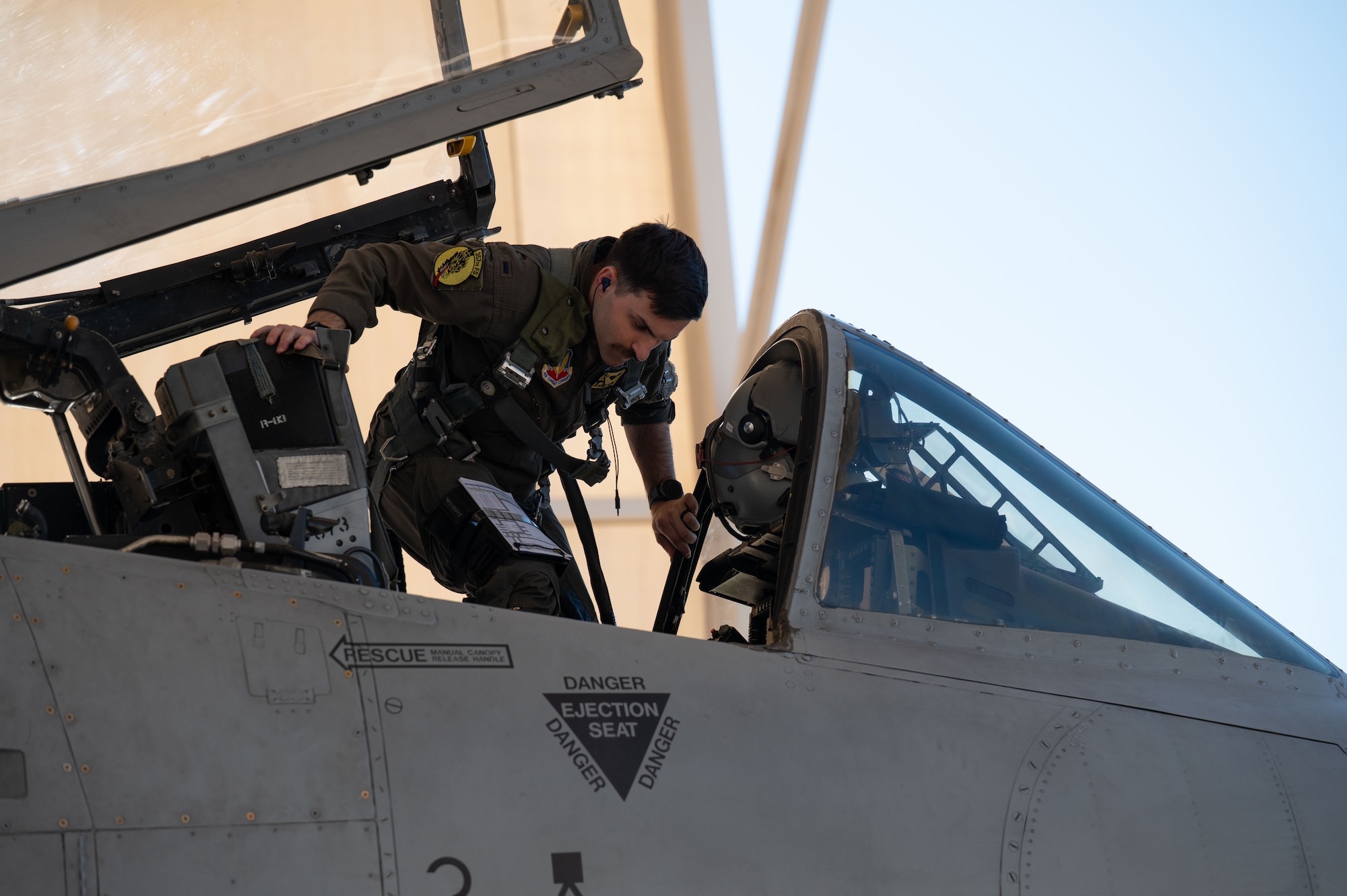 U.S. Air Force 1st Lt. Hunter Mason, a 357th Fighter Squadron A-10C Thunderbolt II pilot, enters an A-10 cockpit at Davis-Monthan Air Force Base, Arizona, March 18, 2026. Mason was going through the final preflight checks before the culminating exercise of his mission qualification training. (U.S. Air Force photo by Airman Najzee Kuzu)