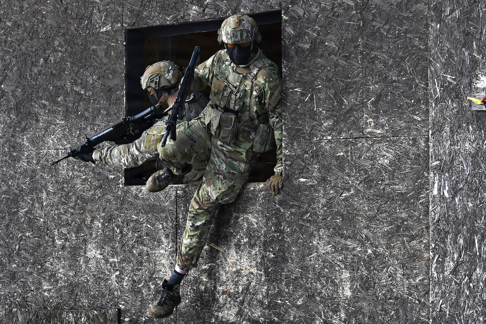 U.S. Army Staff Sgt. James Rudershausen, right, with the Pennsylvania Army National Guard, jumps out of the window of a building while Sgt. 1st Class Sean Kelly, also with the Pennsylvania Army Guard, provides overwatch as the pair competes in the Lithuanian Land Forces Best Infantry Squad Competition in Rukla, Lithuania, March 4, 2026.