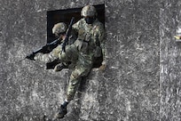 U.S. Army Staff Sgt. James Rudershausen, right, with the Pennsylvania Army National Guard, jumps out of the window of a building while Sgt. 1st Class Sean Kelly, also with the Pennsylvania Army Guard, provides overwatch as the pair competes in the Lithuanian Land Forces Best Infantry Squad Competition in Rukla, Lithuania, March 4, 2026.