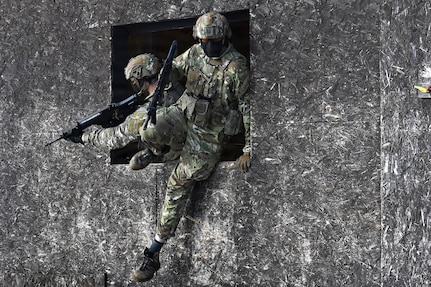 U.S. Army Staff Sgt. James Rudershausen, right, with the Pennsylvania Army National Guard, jumps out of the window of a building while Sgt. 1st Class Sean Kelly, also with the Pennsylvania Army Guard, provides overwatch as the pair competes in the Lithuanian Land Forces Best Infantry Squad Competition in Rukla, Lithuania, March 4, 2026.
