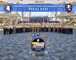 A group photo with accompanying illustration from the opening day of the 22nd iteration of the bi-annual Programa Integral para Suboficiales de Alta Jerarquía, or PISAJ, at Naval Air Station Pensacola, Florida, March 16, 2026. PISAJ is a geo-strategic military engagement led by U.S. Southern Command, U.S. Army Western Hemisphere Command, and U.S. Army South. It is designed to foster mutual growth, professional development, and security collaboration between the U.S. Army, the Colombian military, joint institutions and services, and partner-nation forces. (Photo Credit: U.S. Army photo and graphic illustration by Jose M. Saez)