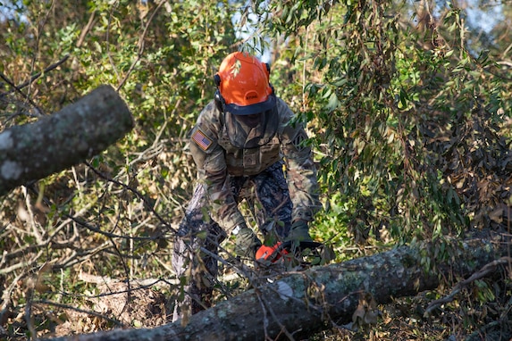 U.S. Army Pfc. Ronell Rolfe, a signal support systems specialist, with the Cumming-based Headquarters and Headquarters Company, 3rd Battalion, 121st Infantry Regiment, 48th Infantry Brigade Combat Team, performs chainsaw duties during a route clearance mission in Cobbtown, Georgia, Oct. 2, 2024. The Georgia National Guard has mobilized to provide response and recovery support to areas in the state impacted by Hurricane Helene. At the direction of the Governor and through The Georgia Emergency Management and Homeland Security Agency (GEMA/HS), the Georgia National Guard will continue to partner local, state, and federal entities in this effort. (U.S. Army National Guard photo by Spc. Ayanna Tillman)