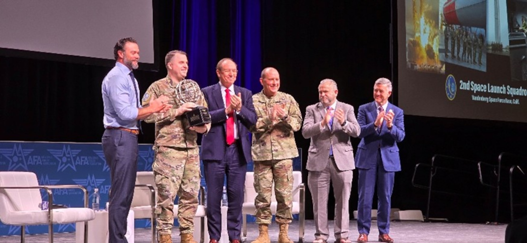 Honorable Matt Lohmeier, Under Secretary of the Air Force, (left) and Retired U.S. Air Force Lt. Gen. David A. Deptula, Mitchell Institute for Aerospace Studies dean, (right) present the 2025 General Atomics U.S. Space Force Unit of the Year award to U.S. Space Force Lt. Col. Andrew Singleton, 2nd Space Launch commander, (second from left) at Air & Space Forces Association 2026 Warfare Symposium in Aurora, Colo. Feb. 24, 2026. The trophy was presented to the squadron at the AFA Warfare Symposium in recognition of their exceptional contributions to the U.S. Space Force mission and embodiment of its core values. (Courtesy Photo)