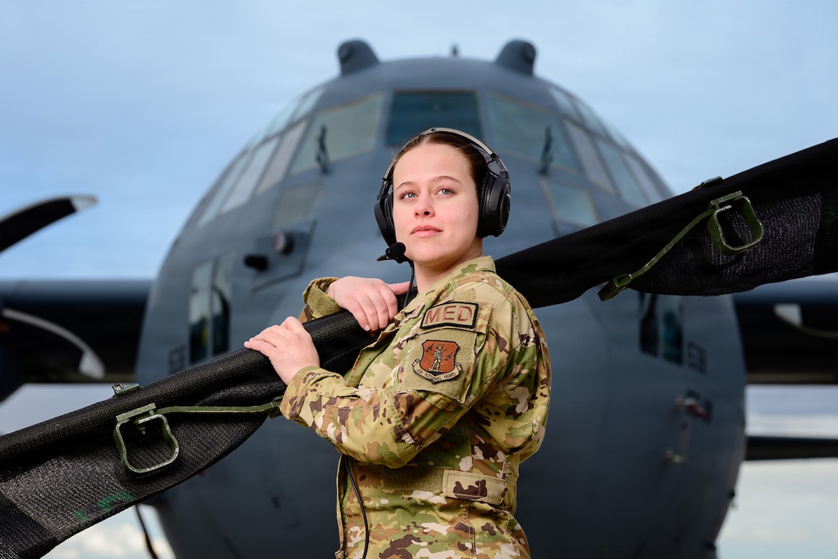 Senior Airman Kaylee Hess, an aeromedical evacuation technician with the 187th Aeromedical Evacuation Squadron, 153rd Airlift Wing, Wyoming Air National Guard, stands in front of a C-130 Hercules aircraft assigned to the 153rd Airlift Wing while holding a folded litter in Cheyenne, Wyo., March 5, 2026