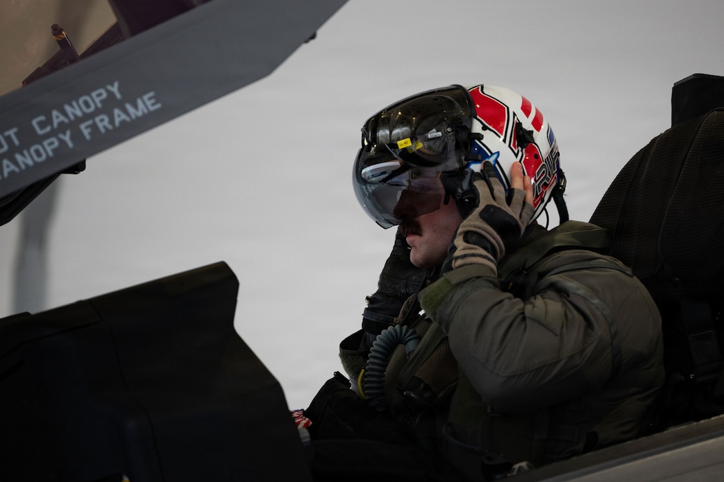 A U.S. Air Force fighter pilot assigned to the 493rd Fighter Squadron dons his flight helmet in preparation for a training sortie during Exercise Cold Response 26 at Ørland Air Force Station, Norway, March 12, 2026.