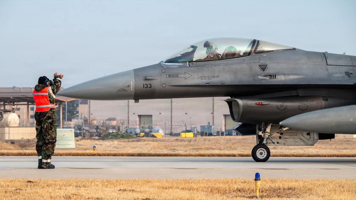 A U.S. Air Force Airman assigned to the 36th Fighter Generation Squadron, instructs an F-16 Fighting Falcon pilot assigned to the 36th Fighter Squadron during exercise Freedom Shield 26 at Osan Air Base, Republic of Korea, March 11, 2026. The exercise tested the ability of Osan Airmen to rapidly generate combat airpower while operating away from their primary installation. (U.S. Air Force photo by Senior Airman Rome Bowermaster)