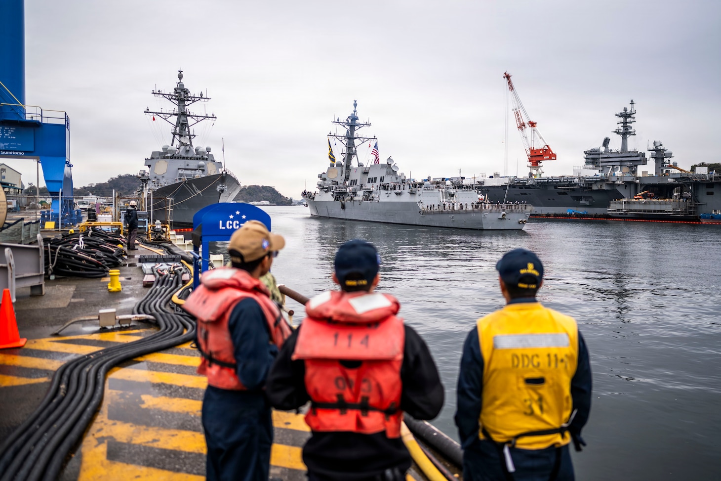 U.S. Navy Arleigh Burke-class guided-missile destroyer USS Mustin (DDG 89), center, arrives at Commander, Fleet Activities Yokosuka, Japan, March 23, 2026.
