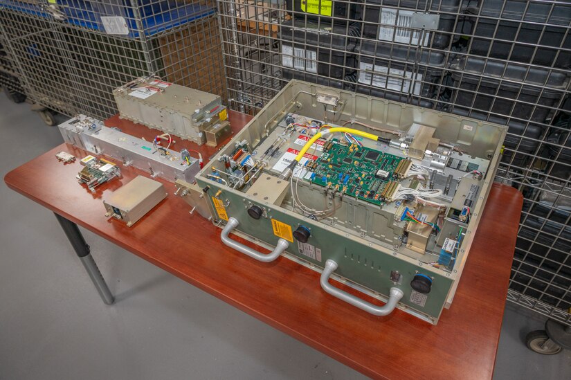 Pieces of a Power Amplifier Module, a piece of military equipment, sit on a table.