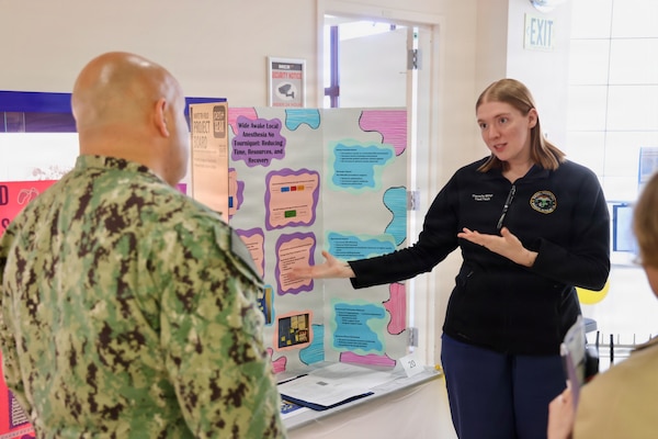 Hospital Corpsman 3rd Class Kaitlyn D. Miller (right) presents her process improvement project to Command Master Chief Richard Moreno (left) during the command process improvement fair at Navy Medicine Readiness and Training Command Twentynine Palms, March 13, 2026. (U.S. Navy photo by Christopher Jones, NMRTC / Naval Hospital Twentynine Palms public affairs officer).