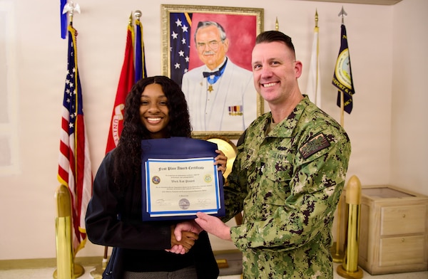 Referral coordinator Jazlyn Antoinette Tharp (left) receives a first-place award from Cmdr. William “Bill” Lawson (right), interim executive officer, during the command process improvement fair at Navy Medicine Readiness and Training Command Twentynine Palms, March 13, 2026. Tharp led the Clear and Legible Reports (CLR) Worklist Project, which improved referral completion rates and streamlined workflow processes. (U.S. Navy photo by Christopher Jones, NMRTC / Naval Hospital Twentynine Palms public affairs officer).