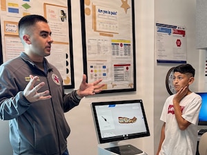 Lt. Joseph Zelasko, a dentist at U.S. Naval Hospital Guantanamo Bay, speaks with students from W.T. Sampson Elementary and High School about oral health, including dental exams, cavities and preventive care, during a field trip March 10, 2026. Student Steven Gomez listens as Zelasko explains how routine dental care supports overall health and readiness. The visit was part of an educational outreach initiative by U.S. Navy Medicine Readiness and Training Command Guantanamo Bay to introduce students to careers in military medicine. (U.S. Navy photo by Emily McCamy)