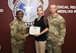 Toni Miklesavage, center, is presented with the Army Civilian Service Commendation Medal recognizing her service as U.S. Army Medical Logistics Command’s Labor Management Employee Relations, or LMER, representative. Pictured with Miklesavage are AMLC Chief of Staff Col. Nikki Davis and Command Sgt. Maj. Gabriel Wright.