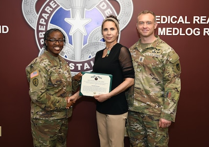 Toni Miklesavage, center, is presented with the Army Civilian Service Commendation Medal recognizing her service as U.S. Army Medical Logistics Command’s Labor Management Employee Relations, or LMER, representative. Pictured with Miklesavage are AMLC Chief of Staff Col. Nikki Davis and Command Sgt. Maj. Gabriel Wright.