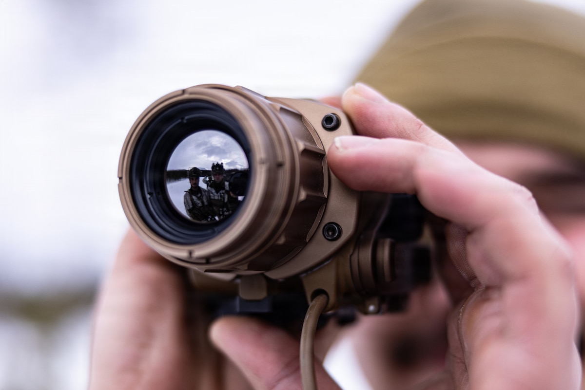 A close-up of a person looking through a weapon sight.