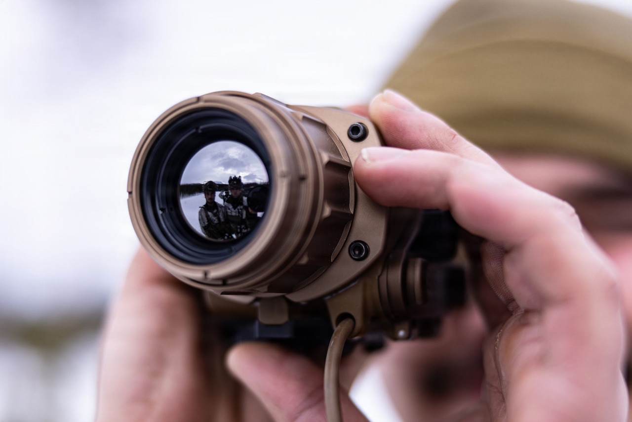 A close-up of a person looking through a weapon sight.