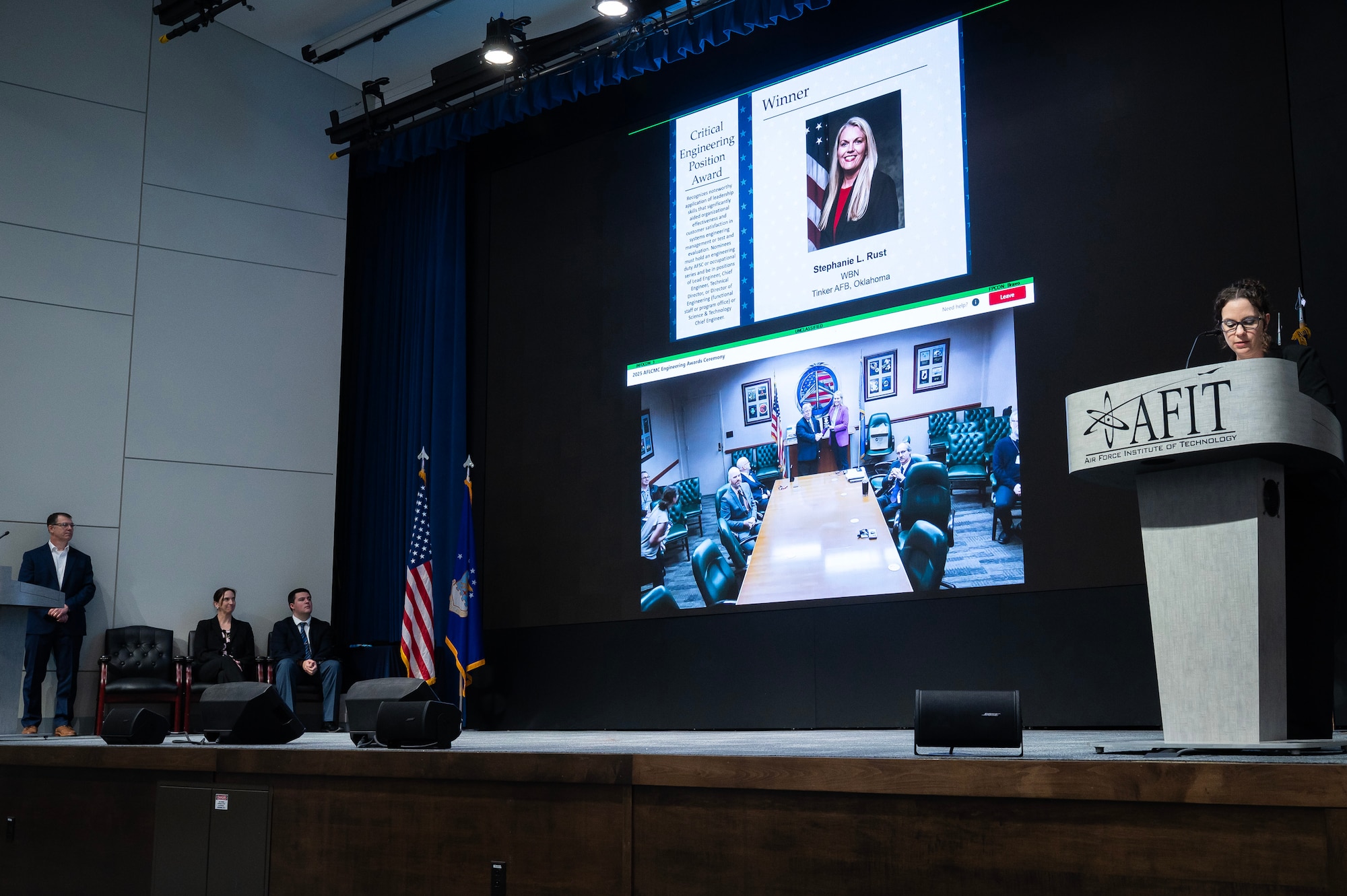 Person standing behind podium on stage.