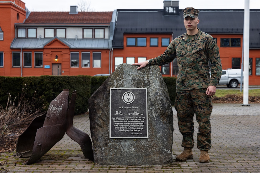 U.S. Marine Corps 2nd Lt. David Cason, a supply officer with Headquarters and Service Battalion, 2nd Marine Logistics Group, poses with a memorial for the U.S. 8th Air Force on Kjeller Air Base, Norway.
