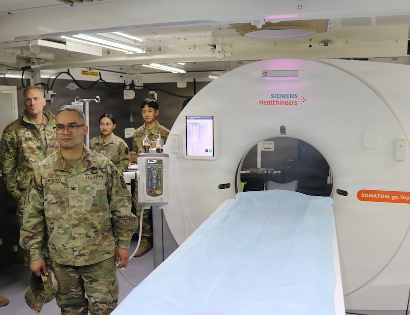 U.S. Army medical personnel inspect, a transportable Field Hospital CT scanner, during a demonstration in a mobile medical shelter.