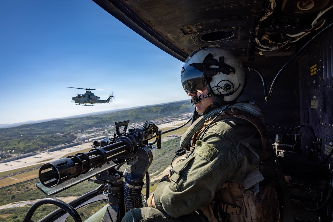 U.S. Marine Corps Cpl. Chase Colbath, a crew chief with Marine Light Attack Helicopter Squadron 367 (HMLA-367), Marine Aircraft Group 39, 3rd Marine Aircraft Wing, surveys the horizon from a UH-1Y Venom  at Marine Corps Base Camp Pendleton, California, March 18, 2026.  HMLA-367 executed a joint live fire exercise alongside joint terminal attack controller assets to refine combat proficiency, strengthen coordination, and enhance operational readiness and lethality. Cobalth is a native of Florida. (U.S. Marine Corps photo by Sgt. Khalil Brown)