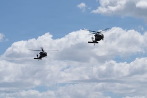 A photo of two military helicopters flying