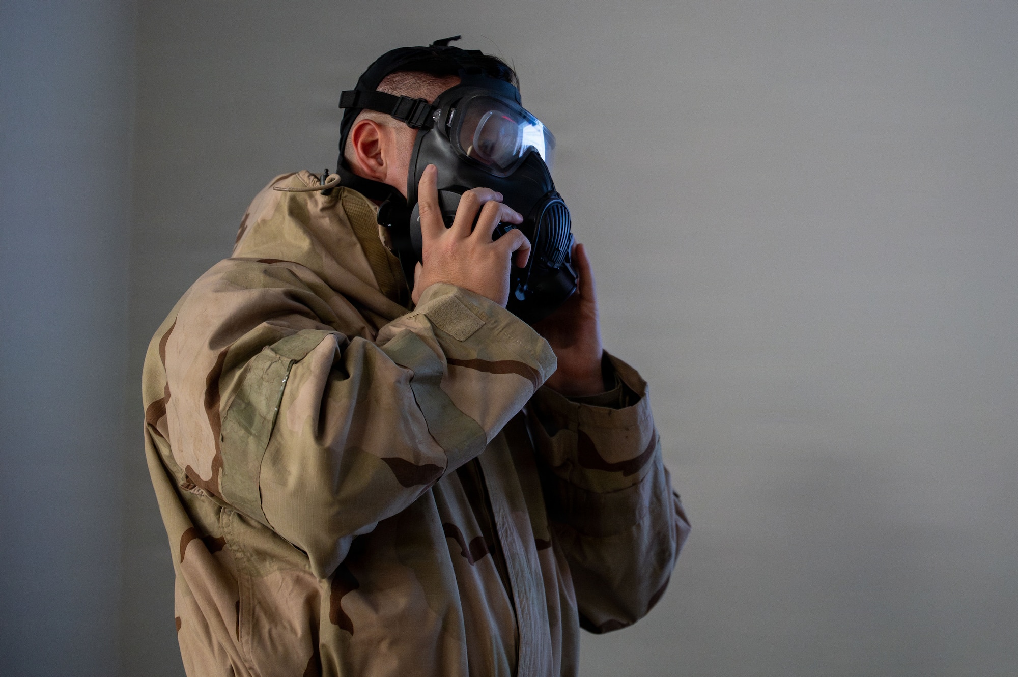 U.S. Air Force Senior Airman Jonathan Kim, 355th Civil Engineer Squadron emergency management technician, demonstrates how to equip mission oriented protective posture gear to Airmen attending Phase I Mission Ready Airman training at Davis-Monthan Air Force Base, Arizona, March 20, 2026. The training ensures first-time combat zone deployers are prepared for any situation they could encounter down-range. (U.S. Air Force photo by Senior Airman Jasmyne Bridgers-Matos)