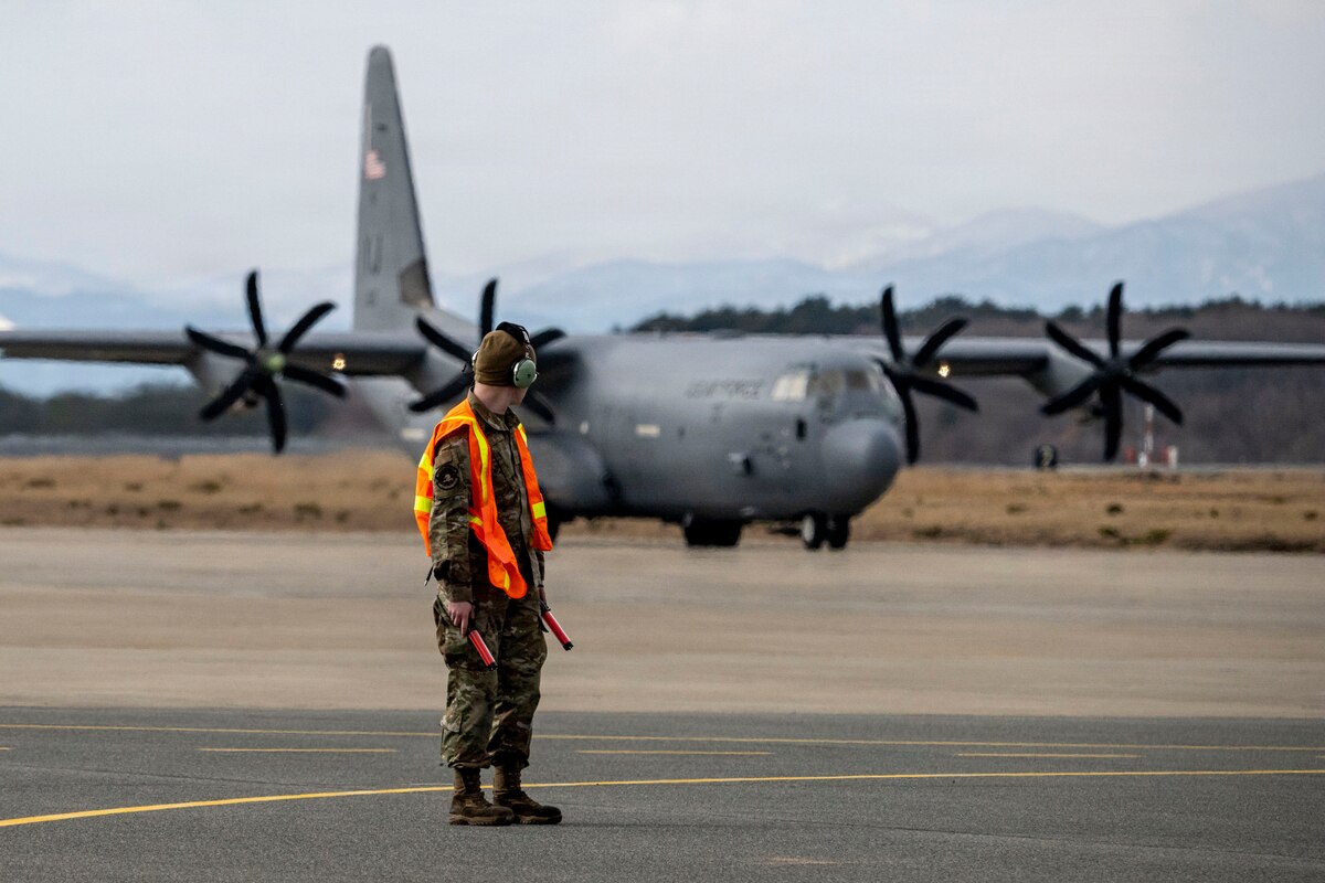 A U.S. Air Force 35th Maintenance Squadron Transient Alert Airman stands ready to marshal a C-130J Super Hercules assigned to the 374th Airlift Wing during Freedom Lift in support of Exercise Freedom Shield at Misawa Air Base, Japan, March 10, 2026.