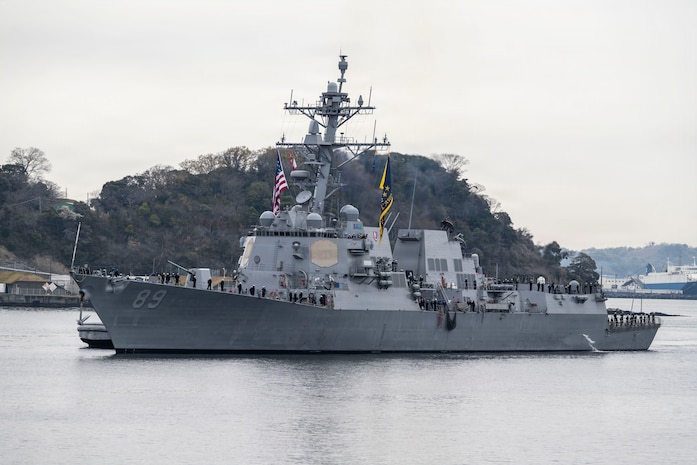 U.S. Navy Sailors man the rails aboard Arleigh Burke-class guided-missile destroyer USS Mustin (DDG 89) as the ship arrives at Commander, Fleet Activities Yokosuka, Japan, March 23, 2026.