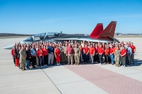Group of people standing in front of T-7A Red Hawk aircraft.