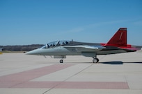 Plane with red tail wing on tarmac.