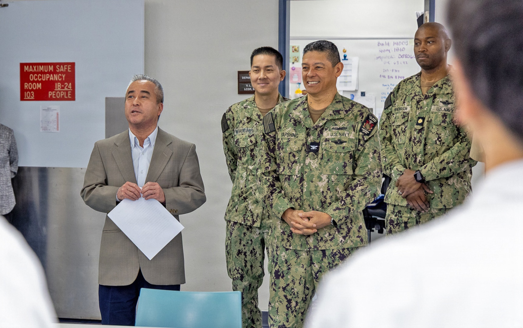 YOKOSUKA, Japan (March 16, 2026) – Mr. Katsuo Konno, a master labor contract employee and galley supervisor at U.S. Naval Hospital Yokosuka, is recognized as Mr. Tomokazu Watanabe, a galley administrative specialist, reads remarks highlighting his contributions during a ceremony at the hospital. Konno was honored for his leadership, dedication and support to galley operations, which directly contribute to patient care and medical readiness. U.S. Naval Hospital Yokosuka ensures warfighter readiness and delivers high-quality health care to forward-deployed forces and their families. (U.S. Navy photo by Daniel Taylor/USNMRTC Yokosuka Public Affairs)