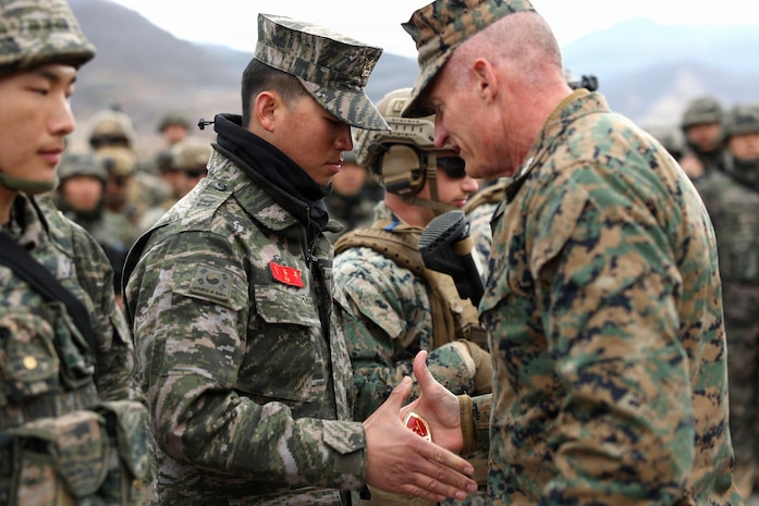 Republic of Korea Marine Corps Staff Sgt. Kim with 1st ROK Marine Division, receives a challenge coin from Lt. Gen. Roger Turner, III Marine Expeditionary Force Commander, during exercise Freedom Shield 26 in Pohang, Republic of Korea, March 16, 2026.