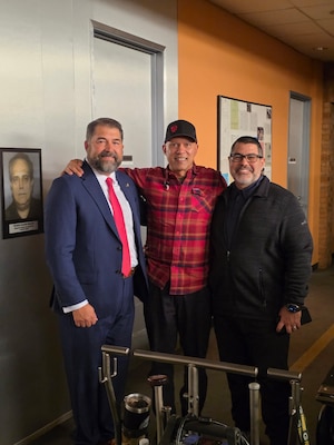 Naval Criminal Investigative Service Director Omar Lopez poses with cast and crew from CBS's NCIS television series on the set in California.