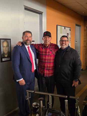 Naval Criminal Investigative Service Director Omar Lopez poses with cast and crew from CBS's NCIS television series on the set in California.